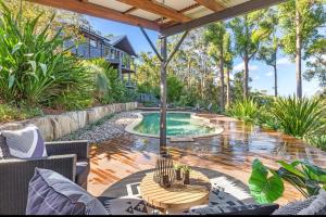an outdoor patio with a pool and a table at Gold Coast Mountain Retreat in Mount Tamborine