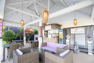 a lobby with a purple couch and tables and chairs at Akusara Jungle Resort And Spa in Nusa Penida