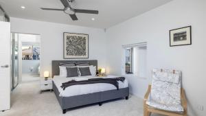 a bedroom with a bed and a ceiling fan at Foreshore Bliss in Salamander Bay