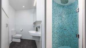 a bathroom with a toilet and a sink and a shower at Foreshore Bliss in Salamander Bay