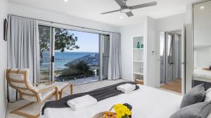 a bedroom with a bed and a view of the ocean at Foreshore Bliss in Salamander Bay