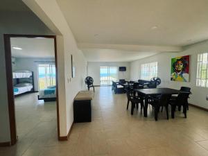 a dining room with a table and chairs and a bedroom at Red Snapper Guest House in Providencia