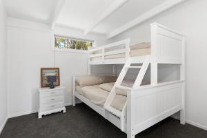 a bedroom with a white bunk bed and a window at Waitorupai Retreat 1 - Sandy Bay Holiday Home in Whangarei