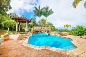a swimming pool with a bench and a gazebo at Hawaiian Dream Temple in Kaupakulua