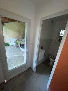 a bathroom with a toilet and a view of a patio at Maisonnette secteur Monastère De Brou proche Centre in Bourg-en-Bresse +4 photos
