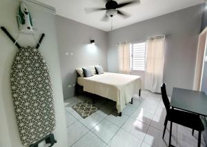 una camera da letto con un letto e un ventilatore a soffitto di Rest Easy at Cunningham Suites 3 & 4 a Ottleyʼs Village