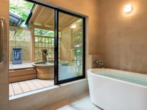 a bathroom with a tub and a large window at Hibikino in Shibukawa