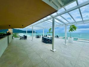 un gran salón acristalado con un patio con vistas al océano en J-PacP506 condo, en Jacó
