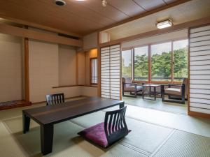 a room with a table and chairs and windows at Hibikino in Shibukawa