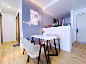 a dining room with a white table and chairs at Hanns modern paradise in Sibu