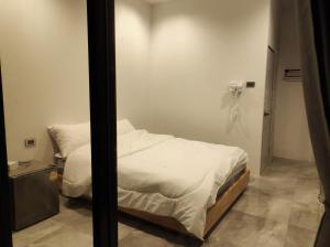 a bedroom with a bed and a phone on the wall at De'La Moon เดอ ลา มูน in Ban Klaeng Bon