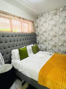 Un dormitorio con una cama grande con almohadas verdes. en 2-BR Apt, Pool access & Balcony, Paulshof, en Sandton