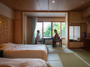 two people sitting at a table in a hotel room at Hibikino in Shibukawa