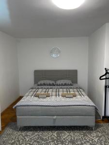 a bed in a bedroom with a white wall at Panorama Royal Vračar in Vračar (historical)