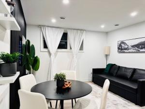ein Wohnzimmer mit einem Tisch und einem schwarzen Sofa in der Unterkunft Luxury Stay Near Niagara Falls in Niagara Falls
