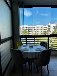 a table and chairs in a room with a large window at APT Luxueux à 5 min de la Plage avec accès Piscine in Bouznika