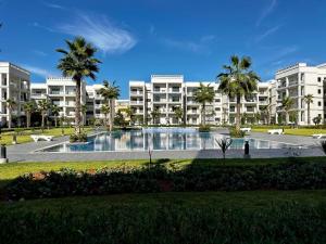 a large apartment building with a large swimming pool at APT Luxueux à 5 min de la Plage avec accès Piscine in Bouznika