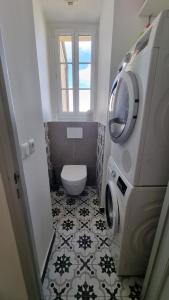 a bathroom with a toilet and a washing machine at Le 16 - Versailles Château in Versailles +13 photos