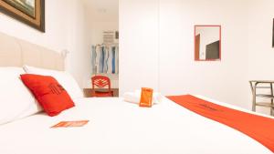 a bedroom with a white bed with red pillows at RedDoorz near Mercado del Lago in Manila