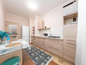 a kitchen with white walls and wooden cabinets at Appartments " Zhetysu-4" in Almaty
