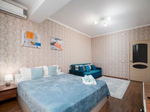 a bedroom with a blue bed and a tv at Appartments " Zhetysu-4" in Almaty +89 photos