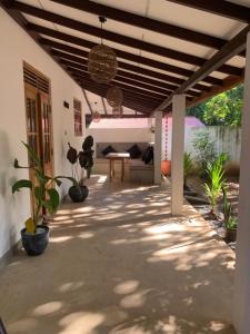 a patio with potted plants and a wooden ceiling at Pranaya Villa in Hiriketiya