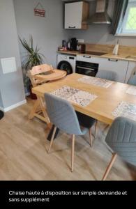 eine Küche mit einem Holztisch und Stühlen in der Unterkunft Gîte le petit wintz 4 personnes avec son jardin privatif - Parking avec borne de recharge pour véhicule électrique 22Kw - 2 vélos in Wintzenheim