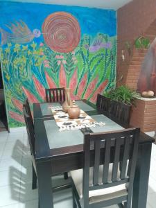 a dining room table and chairs in front of a painting at Aguaribay in Córdoba +8 photos
