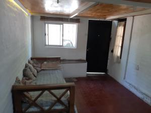 ein leeres Zimmer mit Sofa und Fenster in der Unterkunft Andino in La Cieneguita