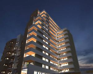 a tall apartment building with its lights on at Departamento Centrico con terraza propia in Río Cuarto