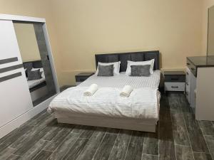 une chambre avec un lit avec des draps blancs et des oreillers dans l'établissement Zara home, à Samarcande