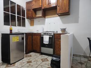 cocina con armarios de madera, fogones y nevera en Casa las Flores, en San Miguel