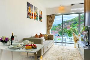 a living room with a couch and a table at Scenic Condo 50 sqm Karon in Karon Beach +17 photos