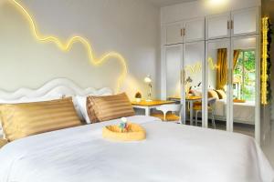 a bedroom with a white bed and a living room at Scenic Condo 50 sqm Karon in Karon Beach