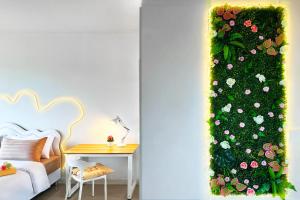 a room with a table and a wall with flowers at Scenic Condo 50 sqm Karon in Karon Beach