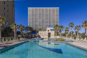 a swimming pool in front of a tall building at Crystal Tower 409 in Gulf Shores