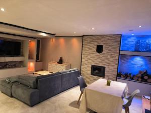 a living room with a couch and a fireplace at Maison cosy 2 chambres proche Troyes in Villacerf