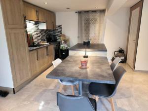 a kitchen with a table and chairs in a room at Maison cosy 2 chambres proche Troyes in Villacerf +8 photos