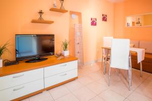 a living room with a tv and a table with chairs at Villa Vita in Polje