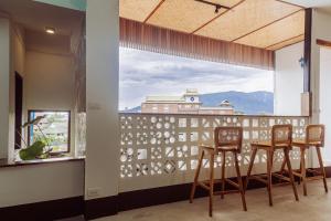 a room with a balcony with chairs and a large window at Eain in Chiang Mai