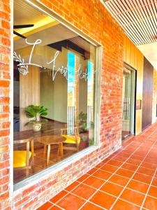 a brick building with a window with a table and chairs at I-VISTA HOTEL in Tawau