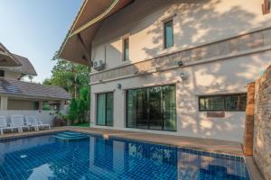 a swimming pool in front of a house at 芭提雅近好莱坞45号三卧别墅 in Pattaya Central