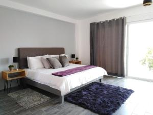 a bedroom with a large bed and a large window at Hotel Xurús Bacalar in Bacalar