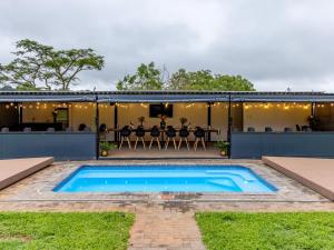 a swimming pool in the backyard of a house with a table at Da Loose Mongoose in White River