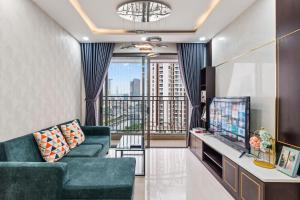 a living room with a couch and a tv at Căn hộ Rivergate - Sài Gòn, Quận 4 in Ho Chi Minh City