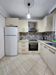 Una cocina con electrodomésticos blancos y un refrigerador blanco. en esa apartman 1, en Trabzon