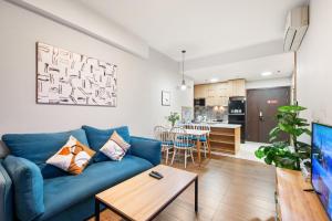 a living room with a blue couch and a table at Căn hộ Rivergate - Sài Gòn, Quận 4 in Ho Chi Minh City