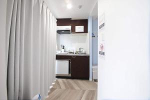 een kleine keuken met een spoelbak en een koelkast bij Shibuya WAVE 302 in Tokyo