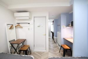 een kleine keuken met een tafel en stoelen in een kamer bij Shibuya WAVE 302 in Tokyo
