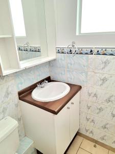 a bathroom with a sink and a toilet at Acogedor departamento veraneo a pasos de la avenida del Mar in La Serena +11 photos